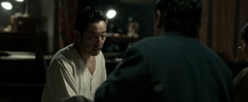 Movie still from “The Outsider” (2018), directed by Martin Zandvliet – A man in white shirt talking to another man in black shirt; Close Up shot, Over the shoulder angle