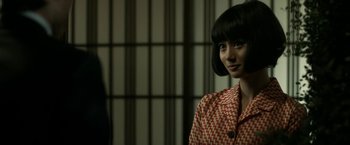 Movie still from “The Outsider” (2018), directed by Martin Zandvliet – A young woman with short black hair wearing a checkered shirt; Close Up shot, Over the shoulder angle