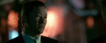 Movie still from “The Outsider” (2018), directed by Martin Zandvliet – A person wearing a suit and tie; Close Up shot, Over the shoulder angle