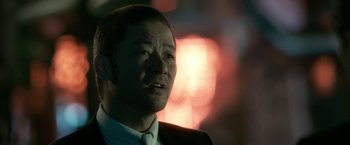 Movie still from “The Outsider” (2018), directed by Martin Zandvliet – A person wearing a suit and tie; Close Up shot, Low angle