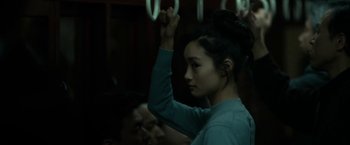 Movie still from “The Outsider” (2018), directed by Martin Zandvliet – A young woman holding her hands up in the air; Close Up shot, Over the shoulder angle