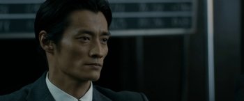 Movie still from “The Outsider” (2018), directed by Martin Zandvliet – A person wearing a suit and tie; Close Up shot, Low angle