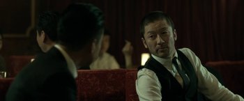 Movie still from “The Outsider” (2018), directed by Martin Zandvliet – A man sitting in front of another man in front of a mirror; Close Up shot, Over the shoulder angle