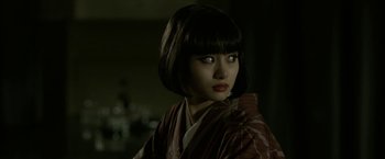 Movie still from “The Outsider” (2018), directed by Martin Zandvliet – A young woman in a kimono is looking at the camera; Close Up shot, Over the shoulder angle