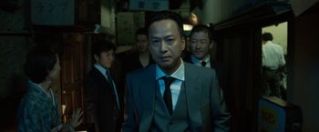Movie still from “The Outsider” (2018), directed by Martin Zandvliet – A group of men standing next to each other in suits; Medium shot, Low angle