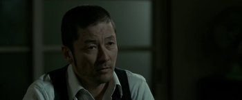 Movie still from “The Outsider” (2018), directed by Martin Zandvliet – A person wearing a shirt and tie; Close Up shot, Over the shoulder angle
