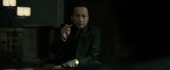 Movie still from “The Outsider” (2018), directed by Martin Zandvliet – A man sitting at a table with a cigarette in his hand; Close Up shot, Over the shoulder angle