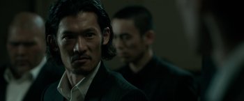 Movie still from “The Outsider” (2018), directed by Martin Zandvliet – A man in a black suit and a man in a white shirt; Close Up shot, Over the shoulder angle
