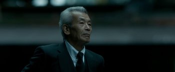 Movie still from “The Outsider” (2018), directed by Martin Zandvliet – An older man wearing a suit and tie; Close Up shot, Low angle