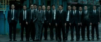 Movie still from “The Outsider” (2018), directed by Martin Zandvliet – A group of men in business suits standing together; Wide shot, High angle