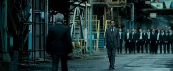 Movie still from “The Outsider” (2018), directed by Martin Zandvliet – A man in a business suit walking down the street; Wide shot, Low angle