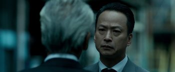 Movie still from “The Outsider” (2018), directed by Martin Zandvliet – A man in a suit and tie talking to another man in a suit and tie; Close Up shot, Over the shoulder angle