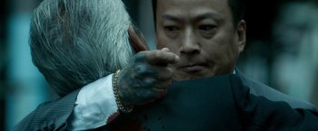 Movie still from “The Outsider” (2018), directed by Martin Zandvliet – A man with a tattoo on his arm is pointing to his face; Extreme Close Up shot, Over the shoulder angle