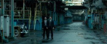 Movie still from “The Outsider” (2018), directed by Martin Zandvliet – A couple of men standing next to each other on a street; Wide shot, High angle