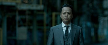 Movie still from “The Outsider” (2018), directed by Martin Zandvliet – A person wearing a suit and tie; Close Up shot, Low angle