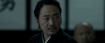 Movie still from “The Outsider” (2018), directed by Martin Zandvliet – A person wearing a black robe; Close Up shot, Over the shoulder angle