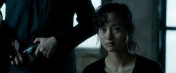 Movie still from “The Outsider” (2018), directed by Martin Zandvliet – A young asian woman looking at the camera; Close Up shot, Over the shoulder angle