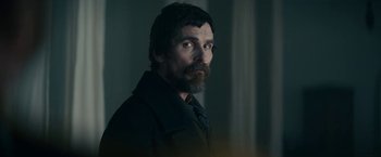 Movie still from “The Pale Blue Eye” (2022), directed by Scott Cooper – A person wearing a suit and tie; Close Up shot, Over the shoulder angle