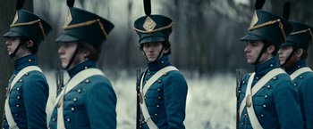 Movie still from “The Pale Blue Eye” (2022), directed by Scott Cooper – A man in a blue military uniform with a rifle; Close Up shot, Over the shoulder angle