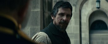 Movie still from “The Pale Blue Eye” (2022), directed by Scott Cooper – A person with a beard; Close Up shot, Over the shoulder angle