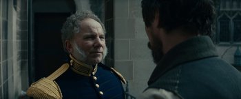 Movie still from “The Pale Blue Eye” (2022), directed by Scott Cooper – A man in a uniform talking to another man; Close Up shot, Over the shoulder angle