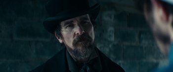 Movie still from “The Pale Blue Eye” (2022), directed by Scott Cooper – A man in a top hat and a black suit; Close Up shot, Low angle