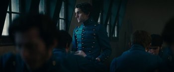 Movie still from “The Pale Blue Eye” (2022), directed by Scott Cooper – A man in a blue military uniform standing in front of a window; Medium shot, Over the shoulder angle