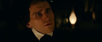 Movie still from “The Pale Blue Eye” (2022), directed by Scott Cooper – A person wearing a suit and tie; Close Up shot, Over the shoulder angle
