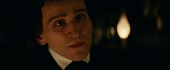 Movie still from “The Pale Blue Eye” (2022), directed by Scott Cooper – A person wearing a suit and tie; Close Up shot, Over the shoulder angle