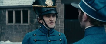 Movie still from “The Pale Blue Eye” (2022), directed by Scott Cooper – A man wearing a uniform and a hat; Close Up shot, Over the shoulder angle