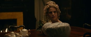 Movie still from “The Pale Blue Eye” (2022), directed by Scott Cooper – A woman in a white dress with a flower in her hair; Medium shot, Over the shoulder angle