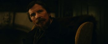 Movie still from “The Pale Blue Eye” (2022), directed by Scott Cooper – A person wearing a suit and tie; Close Up shot, Over the shoulder angle