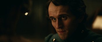 Movie still from “The Pale Blue Eye” (2022), directed by Scott Cooper – A man's face in a dark room; Close Up shot, Over the shoulder angle