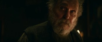 Movie still from “The Pale Blue Eye” (2022), directed by Scott Cooper – An old man with a beard is looking at the camera; Close Up shot, Over the shoulder angle