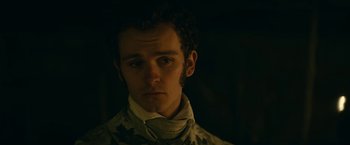 Movie still from “The Pale Blue Eye” (2022), directed by Scott Cooper – A young man in military fatigues stares into the camera; Close Up shot, Over the shoulder angle