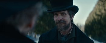 Movie still from “The Pale Blue Eye” (2022), directed by Scott Cooper – A man with a long beard wearing a top hat; Close Up shot, Over the shoulder angle