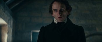 Movie still from “The Pale Blue Eye” (2022), directed by Scott Cooper – A person wearing a suit and tie; Close Up shot, Low angle