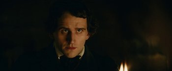 Movie still from “The Pale Blue Eye” (2022), directed by Scott Cooper – A person wearing a suit and tie; Close Up shot, Over the shoulder angle