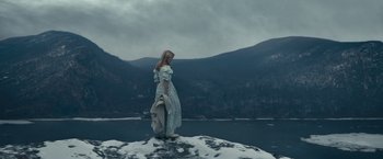 Movie still from “The Pale Blue Eye” (2022), directed by Scott Cooper – A woman standing on top of a snow covered hill; Extreme Wide shot, Low angle