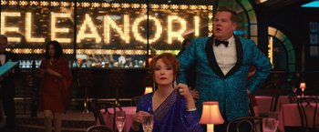 Movie still from “The Prom” (2020), directed by Ryan Murphy – A man and a woman are sitting at a table in front of a neon sign; Medium shot, Over the shoulder angle