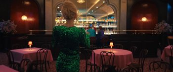 Movie still from “The Prom” (2020), directed by Ryan Murphy – A woman in a green dress standing in front of a bar; Medium shot, Over the shoulder angle