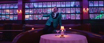 Movie still from “The Prom” (2020), directed by Ryan Murphy – A man in a green jacket standing in front of a table; Wide shot, Low angle