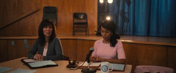 Movie still from “The Prom” (2020), directed by Ryan Murphy – Two women sitting at a table with microphones; Medium shot, Over the shoulder angle