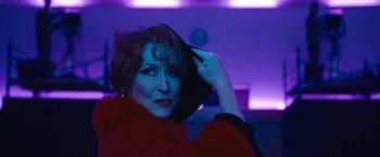 Movie still from “The Prom” (2020), directed by Ryan Murphy – A woman in a red coat holding a hat; Close Up shot, Low angle