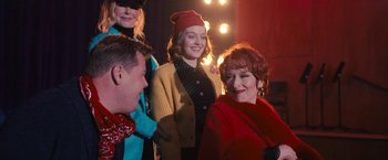 Movie still from “The Prom” (2020), directed by Ryan Murphy – A group of people standing next to each other in front of lights; Medium shot, Over the shoulder angle