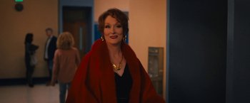 Movie still from “The Prom” (2020), directed by Ryan Murphy – A woman wearing a red coat and a black dress; Medium shot, Over the shoulder angle