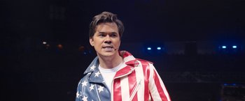 Movie still from “The Prom” (2020), directed by Ryan Murphy – A man in a red , white and blue jacket; Medium shot, High angle