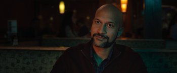 Movie still from “The Prom” (2020), directed by Ryan Murphy – A man with a bald head sitting at a table; Close Up shot, Over the shoulder angle