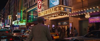Movie still from “The Prom” (2020), directed by Ryan Murphy – People are walking on the sidewalk in front of a theater; Wide shot, Over the shoulder angle