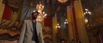 Movie still from “The Prom” (2020), directed by Ryan Murphy – A man standing in front of chandeliers in a building; Medium shot, Low angle